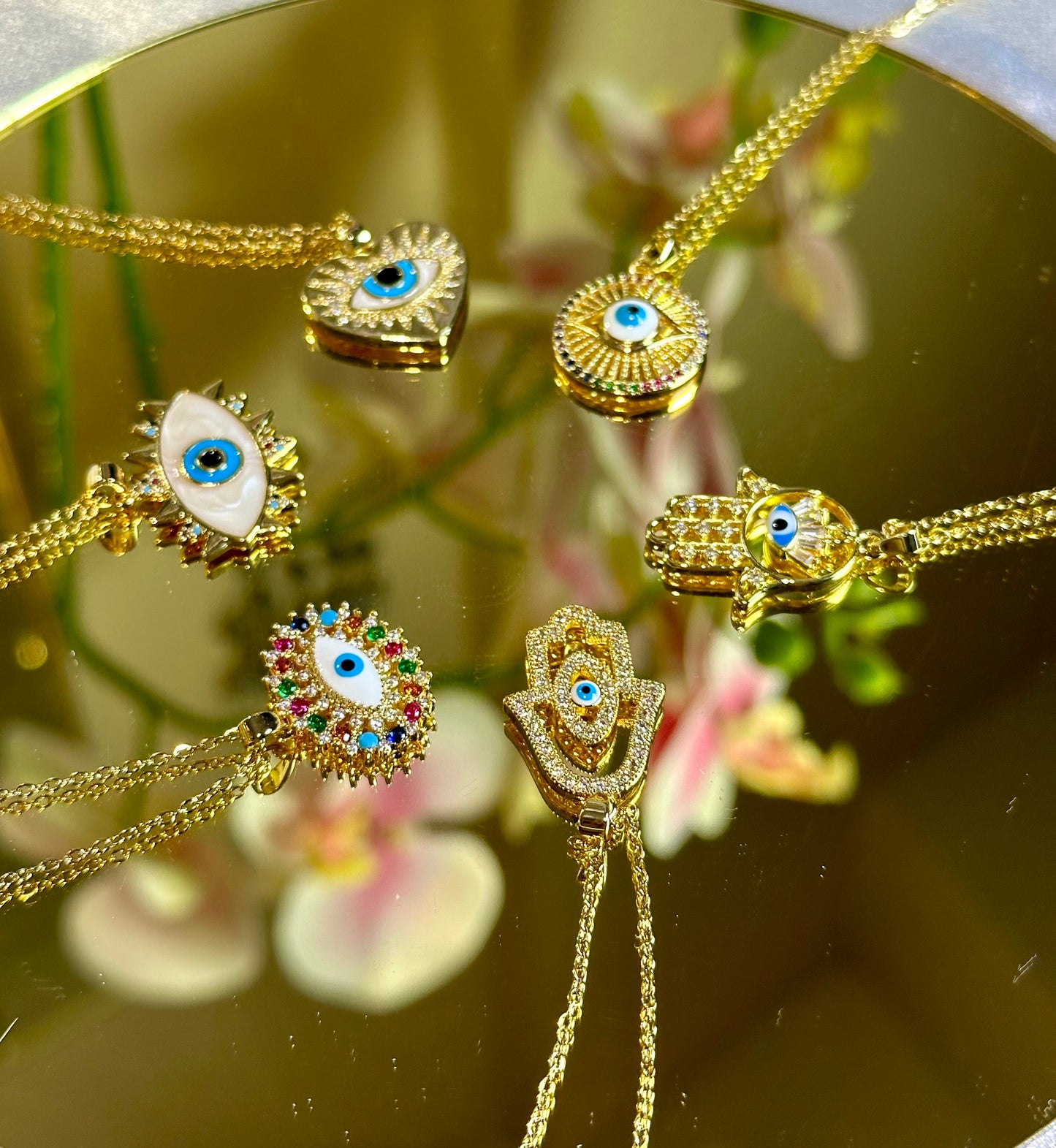 Evil Eye Pendant Necklace with 18K gold and blue design on a mirror.