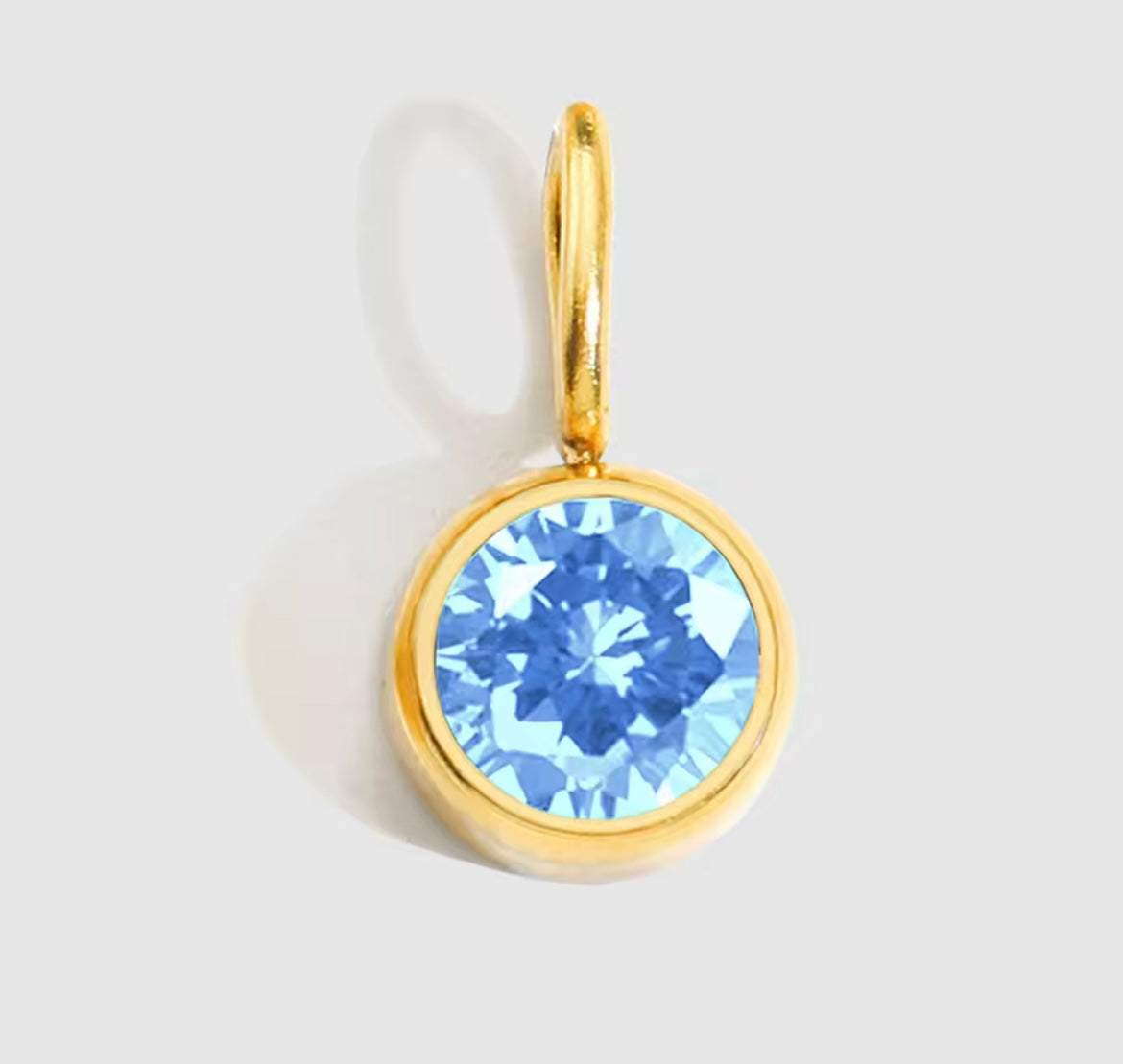 Gold-plated birthstone charm necklace with blue pendant on an adjustable chain.