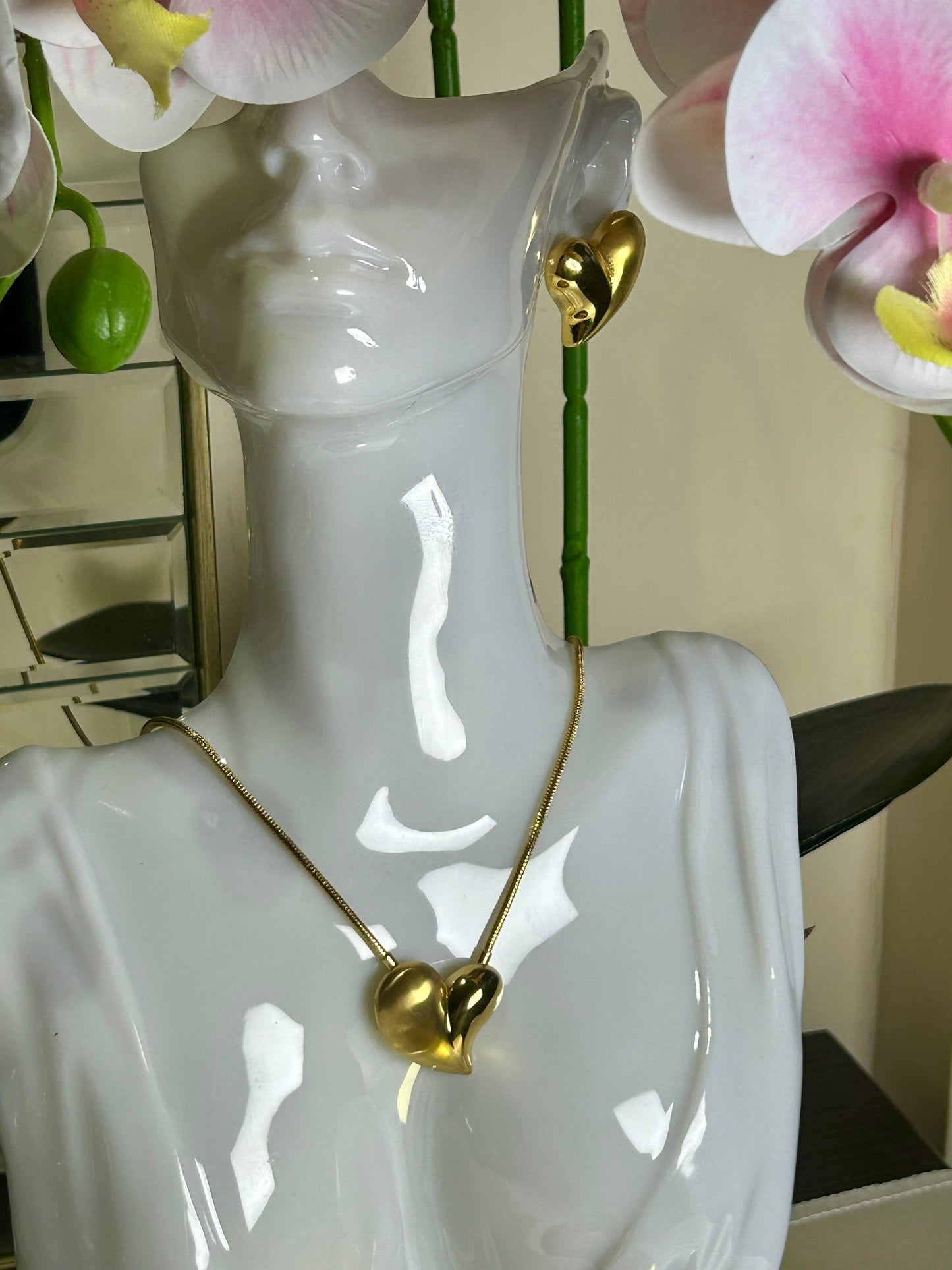Heart Charms Love Earrings and Necklace in 18k gold plated stainless steel displayed on a mannequin.