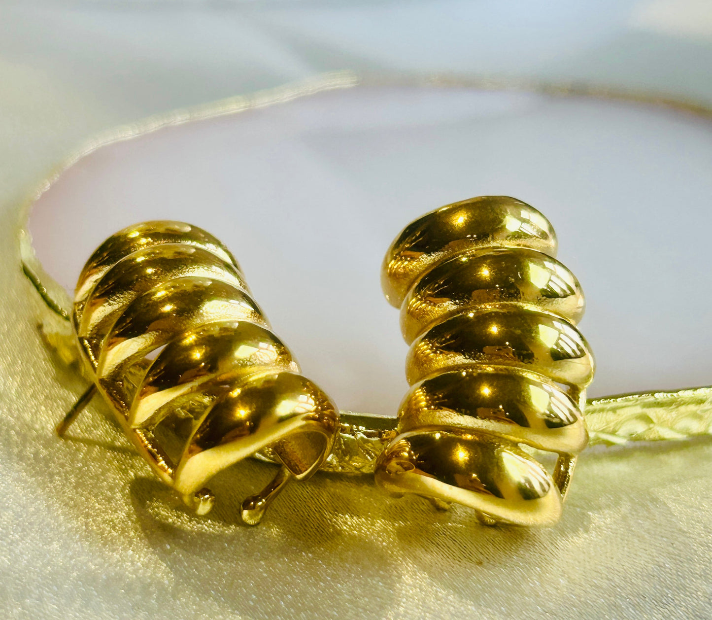 Striped Hollow Women Earring in gold-plated stainless steel on a soft background.