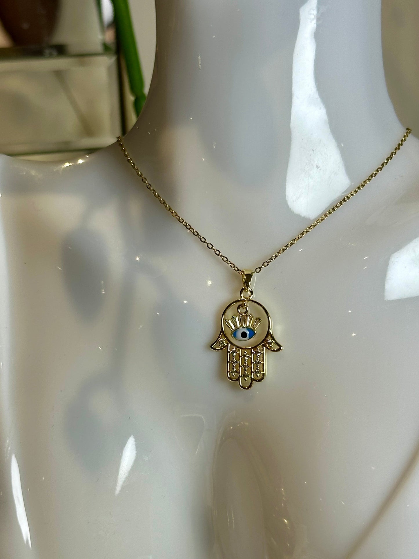 Evil Eye Pendant Necklace with 18K gold and blue design on stainless steel chain.
