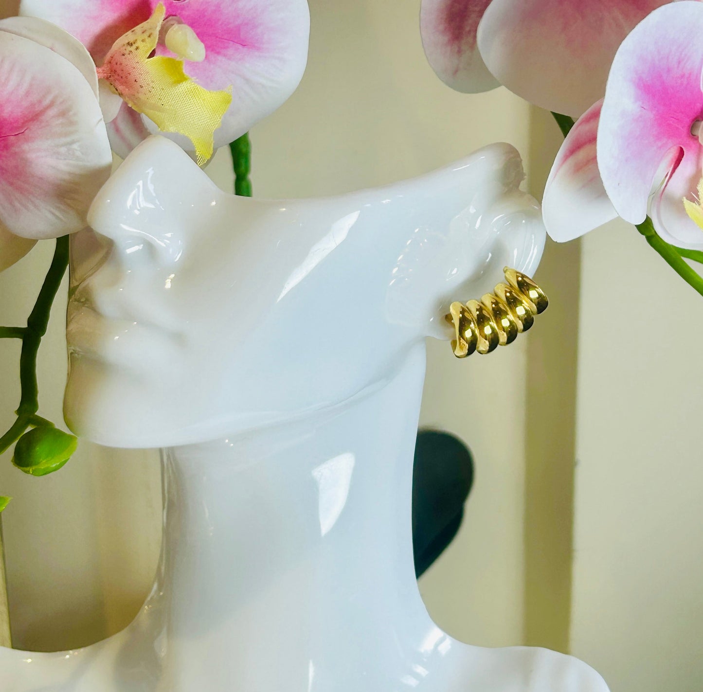 Striped Hollow Women Earring with 18k gold plating displayed on a mannequin amidst pink flowers.