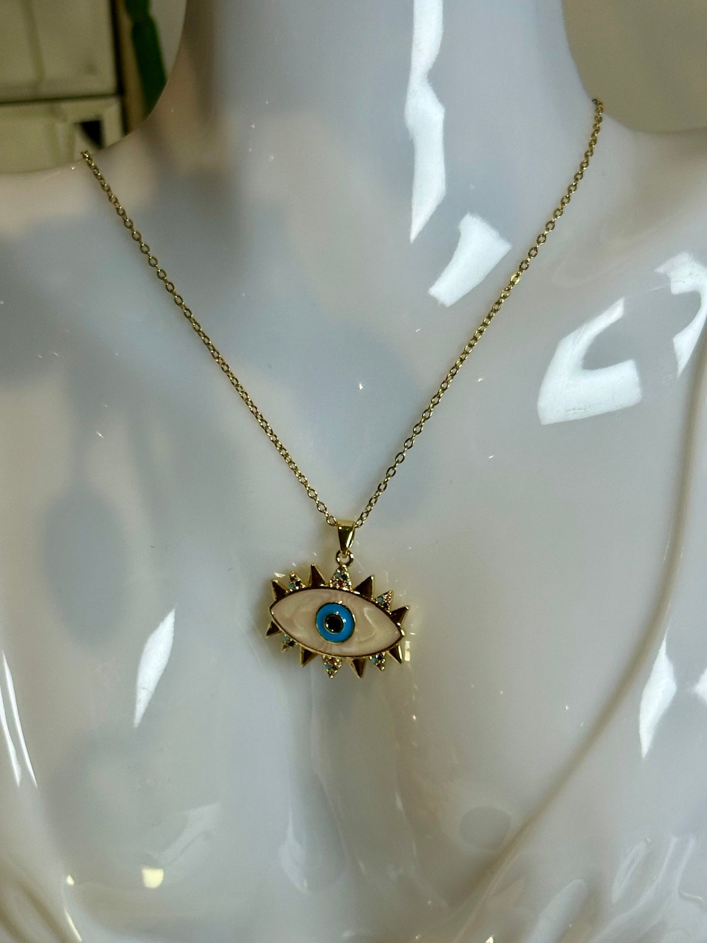 Evil Eye Pendant Necklace in 18K gold with blue design on stainless steel chain.
