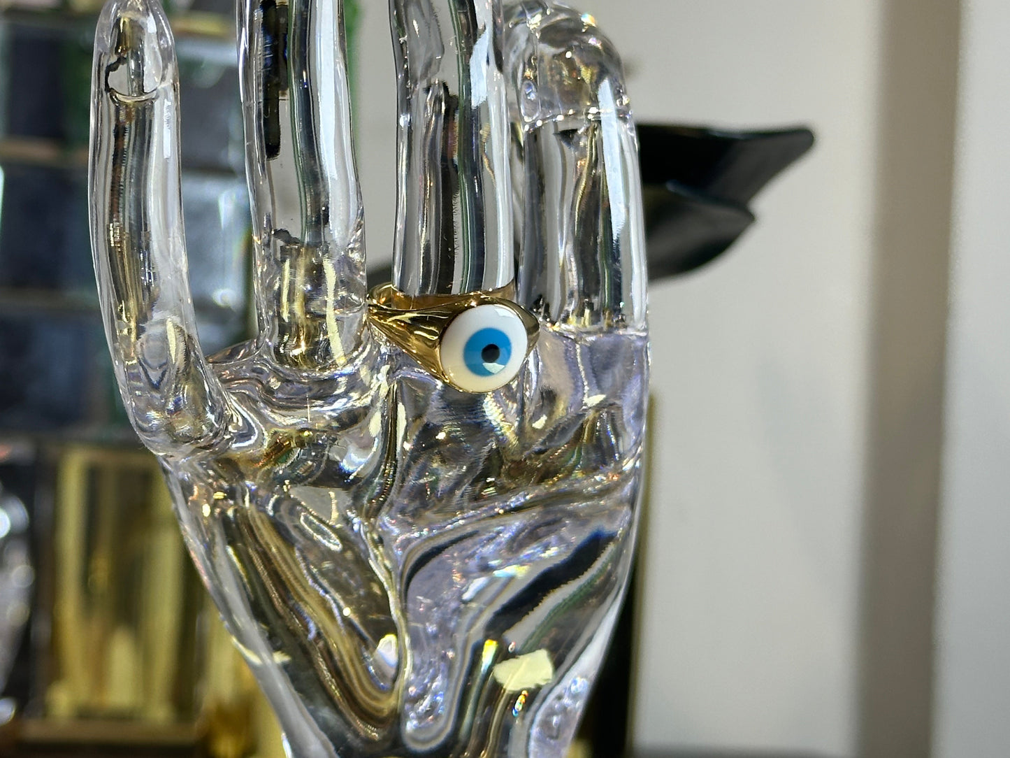 Devil Eye Rings Size 7 in 18K gold plated stainless steel on glass hand display.
