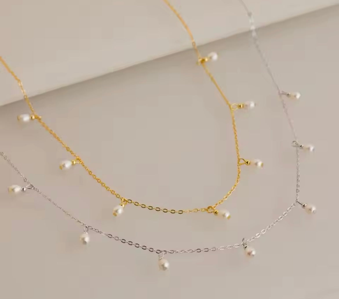 Gold-plated stainless steel teardrop imitation pearl necklace with adjustable chain.