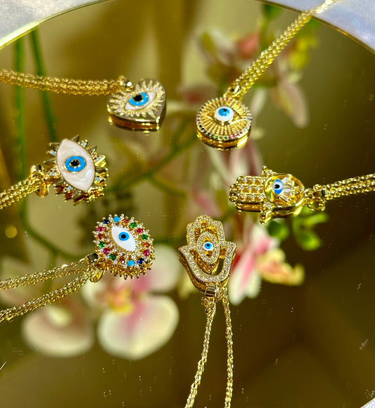 Evil Eye Pendant Necklace with 18K gold and blue design on a mirror.