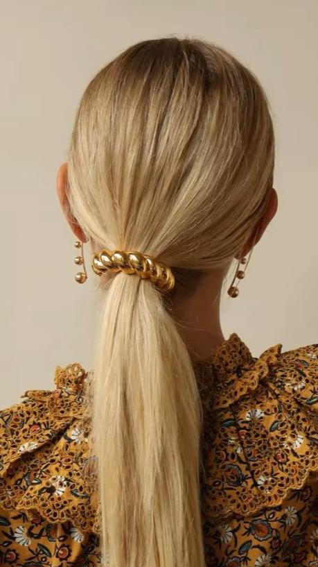 Chunky semi-circular twist black rubber band hair tie in blonde hair.